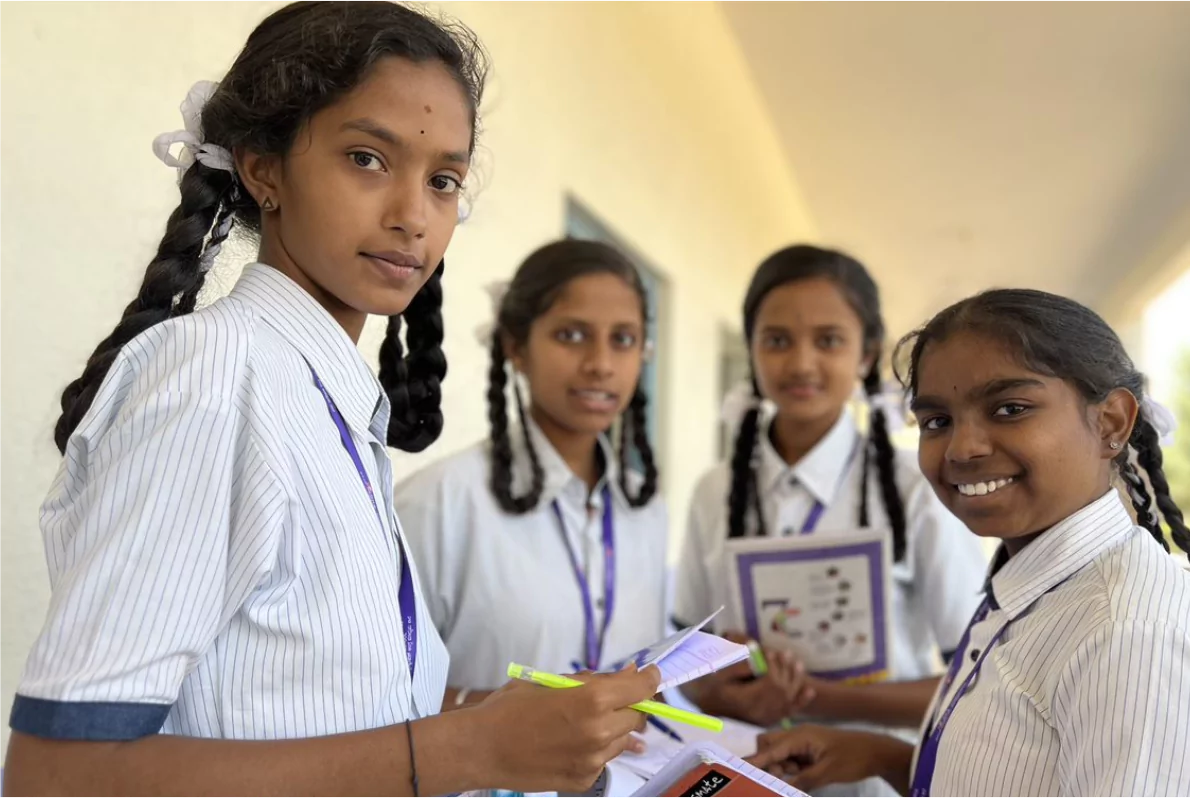 Students with notebooks walking through a school corridor